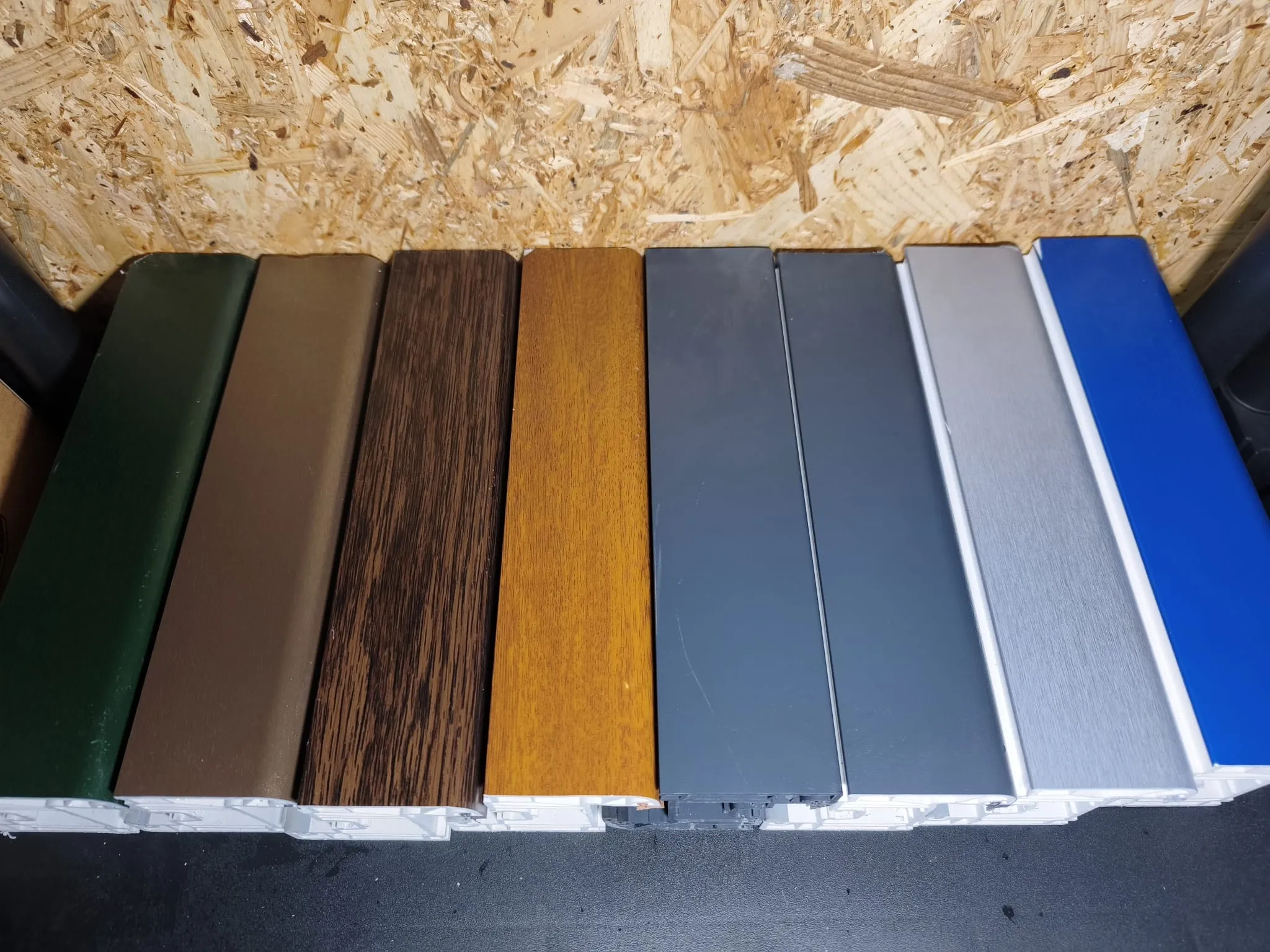 Amostras de perfis em PVC: verde, castanho, imitação de madeira, cinzento, branco e azul