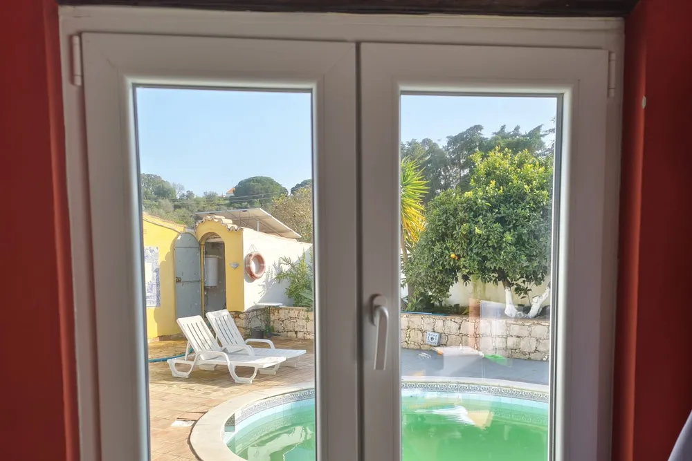 Janela em PVC à medida instalada numa moradia no Algarve, com vista para a piscina